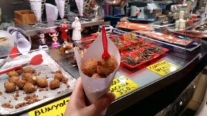 Bunyols de Bacalao - Cod fritters in a cone at a market stall -Barcelona street food