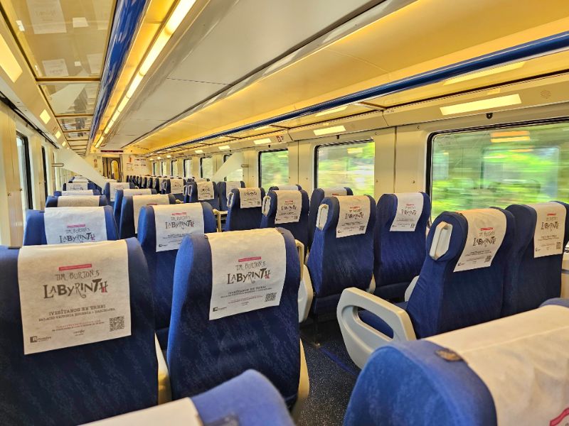 Inside The Train from Barcelona to Tarragona with rows of blue seats