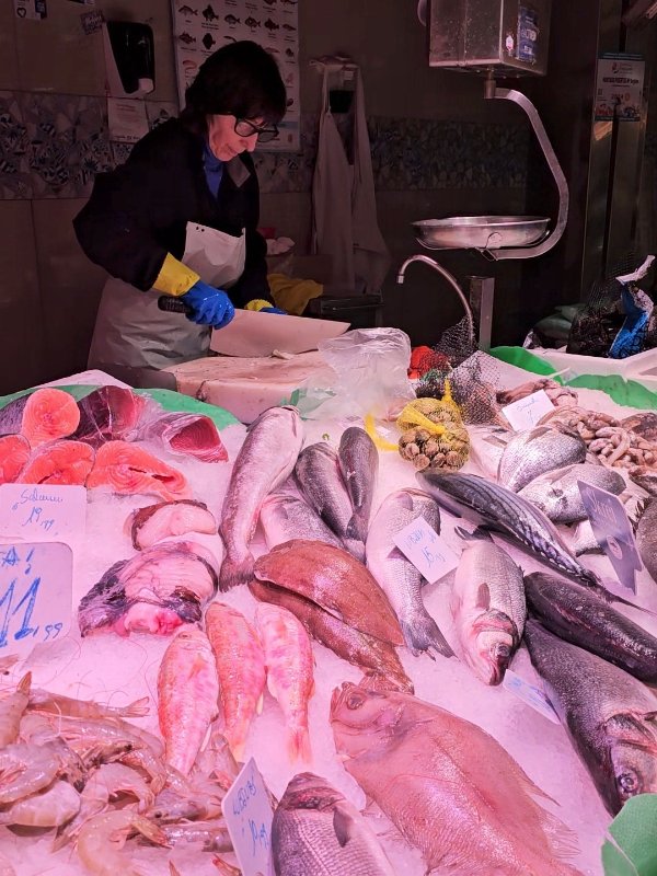 Buying Seafood from the Boqueria Market as part of the Cooking Class - A Fish Stall with a Woman Cutting FIsh with a Huge Knife