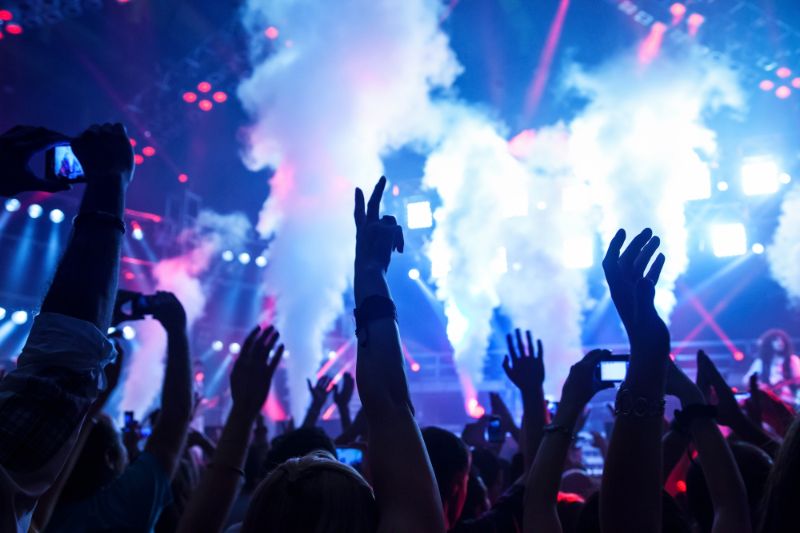 Hands in the air in a dark nightclub with dry ice in the background - Celebrate New Year in a Barcelona Nightclub 