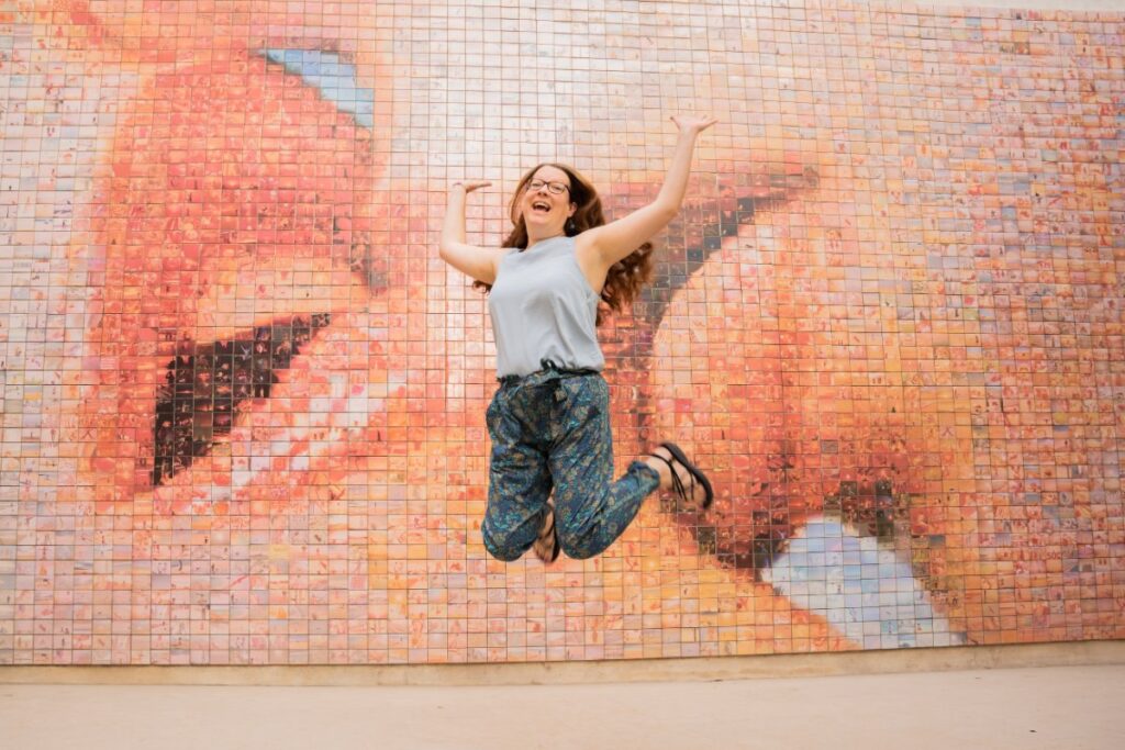 Claire Jumping at the Kiss Mural - The Best Barcelona Instagram Spots