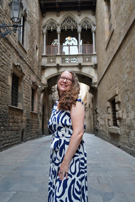 Claire smiling under the Pont del Bisbe in the Gothic Quarter