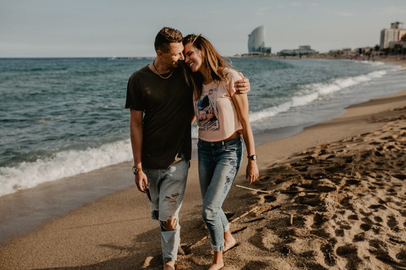 Couple taking a walk on the beach in Barcelona - One of the Most Romantic Things to do in Barcelona